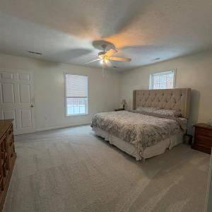 Primary main level bedroom with new carpet.  Has its own bath and walk in closet.