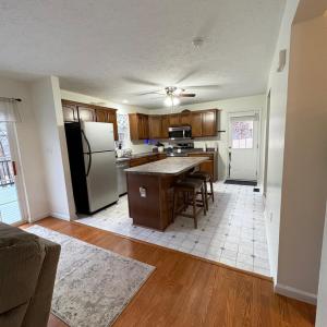 Kitchen with new flooring and exit to side yard. Refrigerator, dishwasher, microwave and stove installed 11/25.