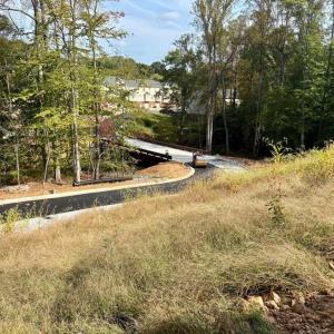 Bridge and newly paved entrance into Creekside surrounded by nature!