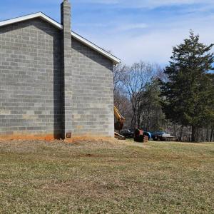 Side of garage with flue for woodstove.