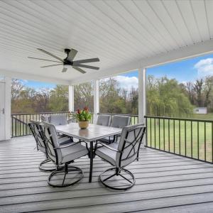 Screened porch with stairs leading to the level, large backyard