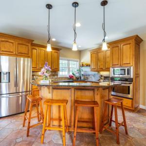 Kitchen with bar seating, custom cabinets, granite, induction cooktop, and tile! Easy access to the garage entry.