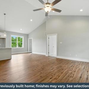 Open-concept interior featuring LVP flooring, cathedral ceilings, recessed lighting, and a ceiling fan
