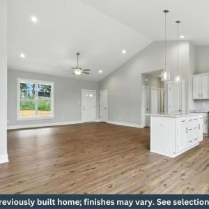 Open-concept living space featuring LVP flooring, a cathedral ceiling with recessed lighting and a ceiling fan, and a kitchen island with pendant lighting