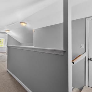 Spacious carpeted bedroom loft with sizable closet and multiple attic access is with ample storage and a private half bath.
