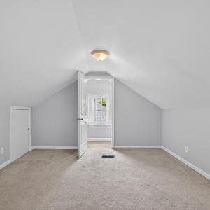 Spacious carpeted bedroom loft with sizable closet and multiple attic access is with ample storage and a private half bath.