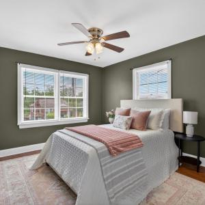 Spacious bedroom with designer updated paint and ceiling fan.