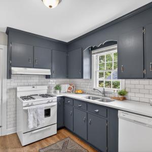 Updated kitchen with subway tile, backsplash, quartz counters, hardwood floors, and a walkout back porch. Window view over sink.
