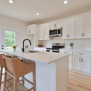 Open Concept kitchen with quartz counters, oversized island, door to deck, etc *Fridge ordered and scheduled to be installed.