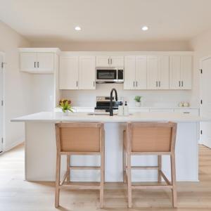 Open Concept kitchen with quartz counters, oversized island, door to deck, etc *Fridge ordered and scheduled to be installed.