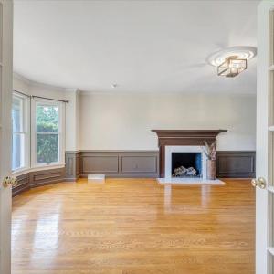 Living room accented by a gas log fireplace and large bay window