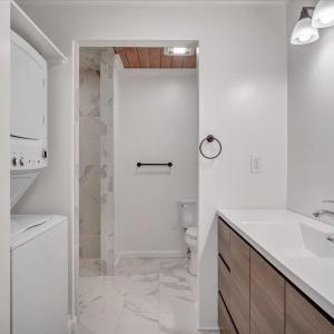 Full bath with laundry closet completes the in-law apartment.  A tankless on demand hot water system serves the in law apartment.