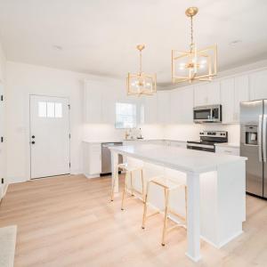 Open kitchen with 6 ft island, under cabinet lighting, white shaker cabinets and quartz countertops.  Similar to photos.