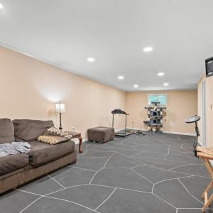 The large "rec room" on terrace level. The window wall and the wall behind the couch (front wall of house) had  carbon fiber strips installed, sump pump installed, french drain installed