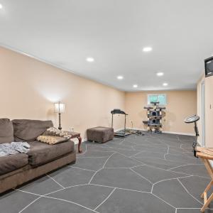 The large "rec room" on terrace level. The window wall and the wall behind the couch (front wall of house) had  carbon fiber strips installed, sump pump installed, french drain installed