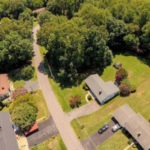 Home with adjoining lot, wooded area to the left of the home.