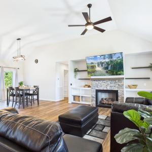 Open Floor Plan featuring Vaulted Ceilings, Stone Fireplace, Built-In Shelving, Luxury Vinyl Plank Flooring, and abundant Natural Light.