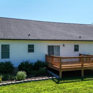 Spacious Rear Deck overlooks the Level Backyard with Established Landscaping and Outdoor Living Space.