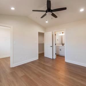 Primary Suite with vaulted ceilings, walk in closet and en suite full bathroom.