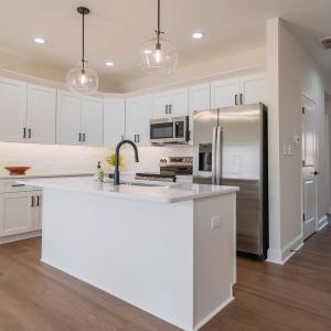 Open concept, custom kitchen. Tile backsplash, open to dining and living area. Finishes may not be identical but similar.