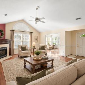 Virtually staged living room leading into the sunroom