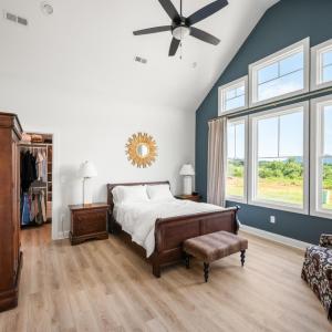 Main level primary suite with natural sunlight, large window, and mountain views
