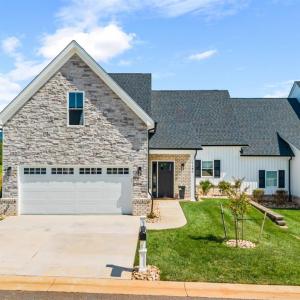 Beautiful stone, vinyl and brick exterior with flat concrete driveway