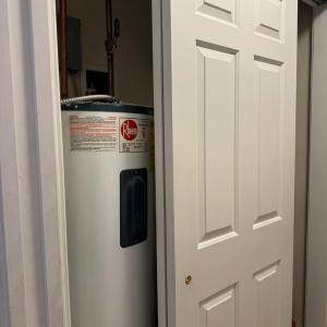 Large Pantry cupboard holds the Reem water heater and...