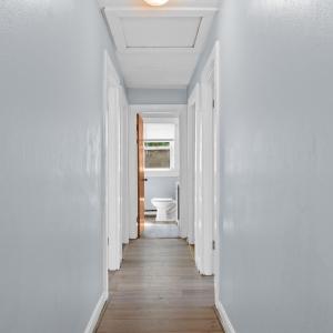 Heading down the hall to bedrooms, bath, kitchen, slider to deck! Pull down attic door here in the hallway