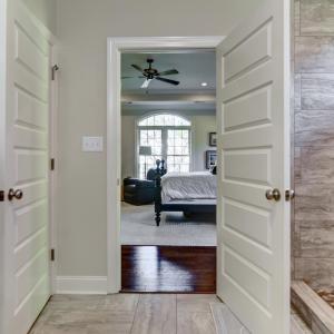 View from Bathroom sink area, towards primary bathroom entry, shower and water closet on the left
