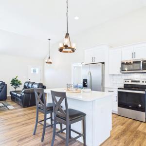 Kitchen/Living Room , Granite Countertops, Large Kitchen Island, Stainless Steel Appliances, White Cabinetry, and Open Kitchen Design.