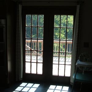 French doors lead from kitchen/dining area to deck