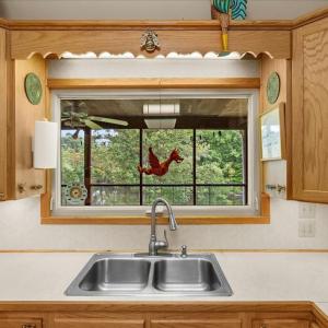 Primary Kitchen - Main Floor, The roll-out window expands the kitchen by inviting summer dining on the porch.