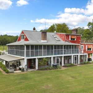 Southeast Side of home, Screened Porches expand the living space into the outdoors on the main and lower levels, with a greenhouse attached