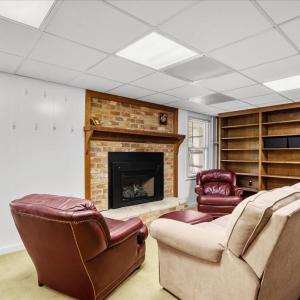 Living Room - Suite 2 Basement, Library shelves and gas logs in the fireplace encourage sneaking away for a good read.