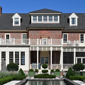 Waterfront/rear side of house, Left bottom library windows. Right side screed dining porch, and above each are observation decks off 2 of the bedrooms w/ additional center hall entrance