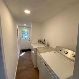 nice laundry room, New Maytag washer and dryer with a new water heater tucked away in a closet offers a little more storage space.