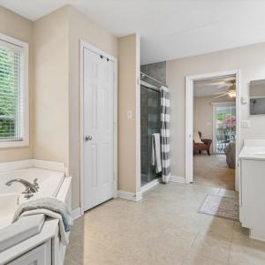 Primary Bathroom w/dual sinks, walk-in tile shower, and large soaking tub.