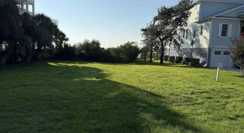 View of green lawn featuring a garage
