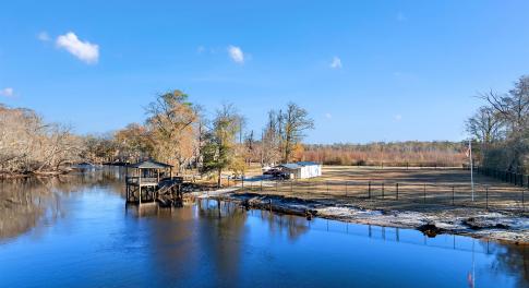 View from the river featuring a gazebo and a boat