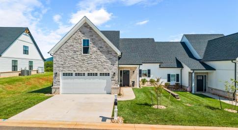 Beautiful stone, vinyl and brick exterior with flat concrete driveway